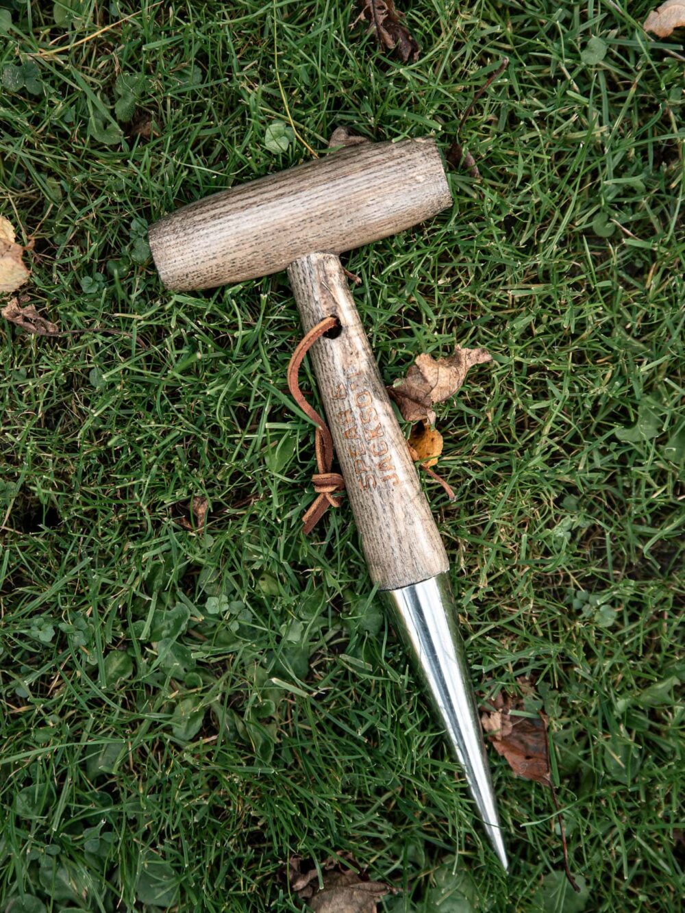 dřevěný sázecí kolík s kovovou špičkou v trávě
